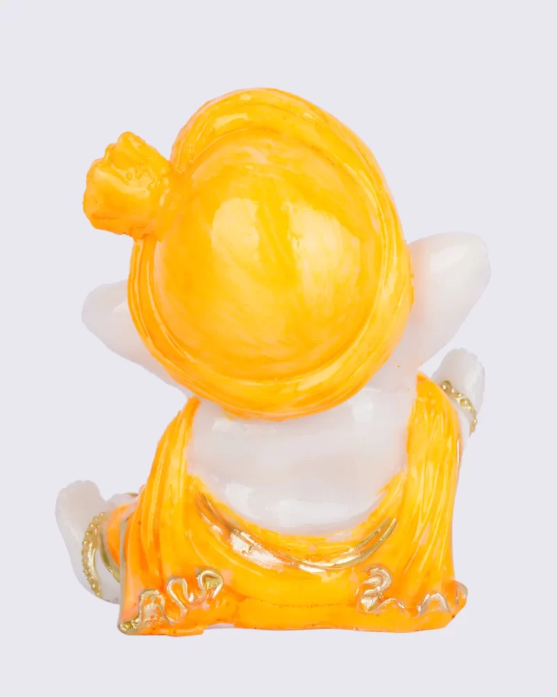 Miniature yellow Ganesha statue, representing success and good fortune